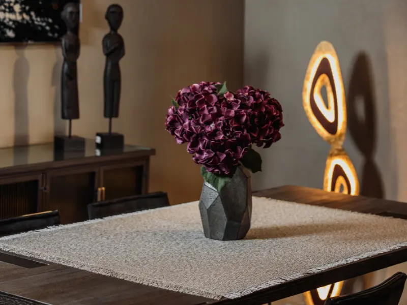 Détail d’un intérieur de style colonial avec bois foncé, motifs asiatiques et lumière douce